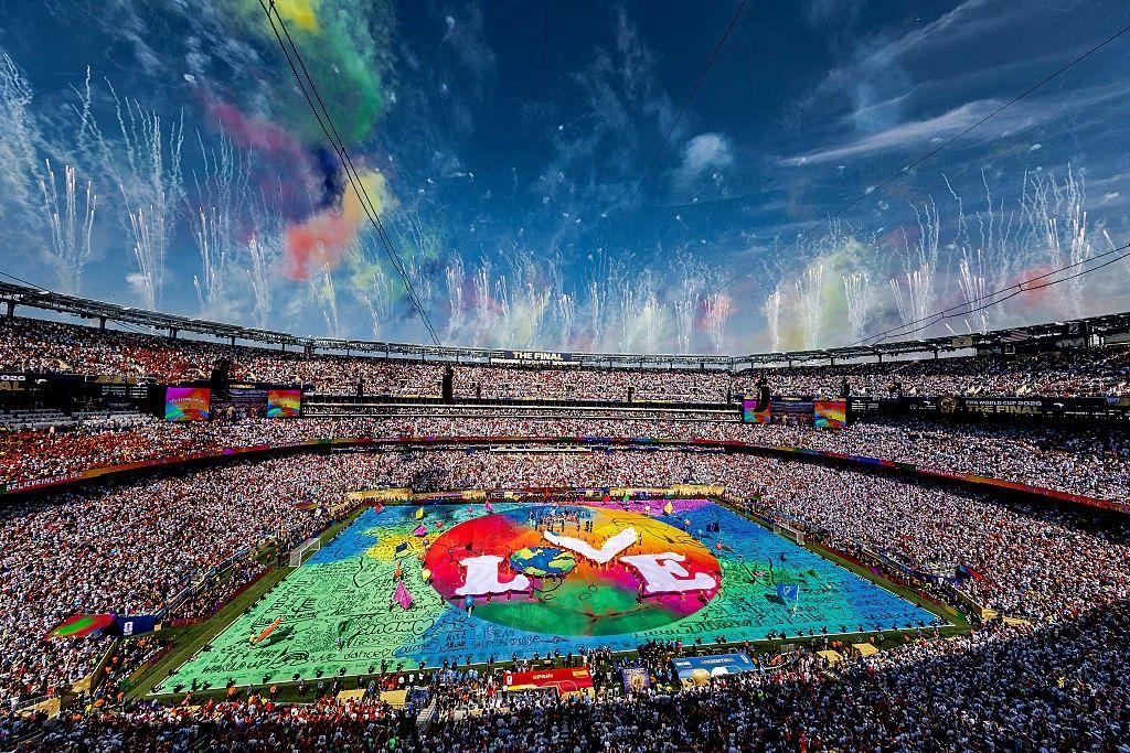Una toma amplia del estadio con un escenario colorido en el centro y la palabra "love" (amor) escrita en medio.