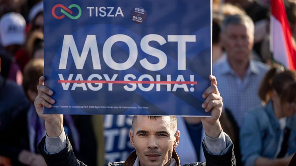 Mađarov pristalica drži transparent na kojem piše „Sad”, dok su reči „ili nikad” precrtane