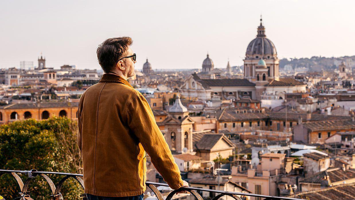Un hombre asomado a un balcón en Roma. 
