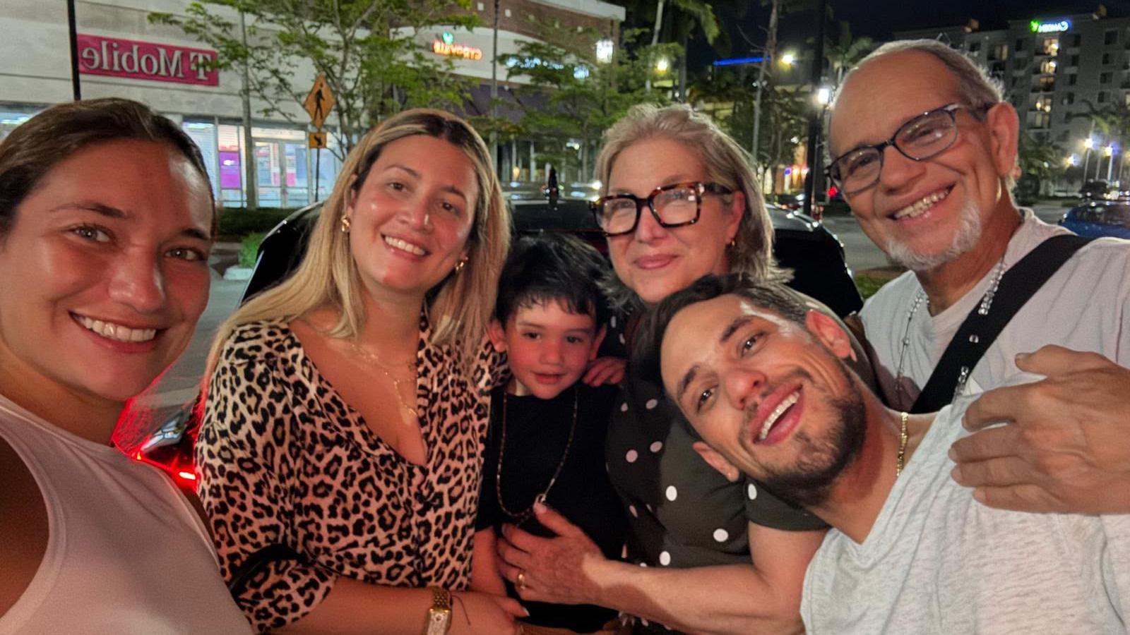 Claudia Rodríguez, sonríe a cámara en una selfie en la que también se ve a miembros de su familia.