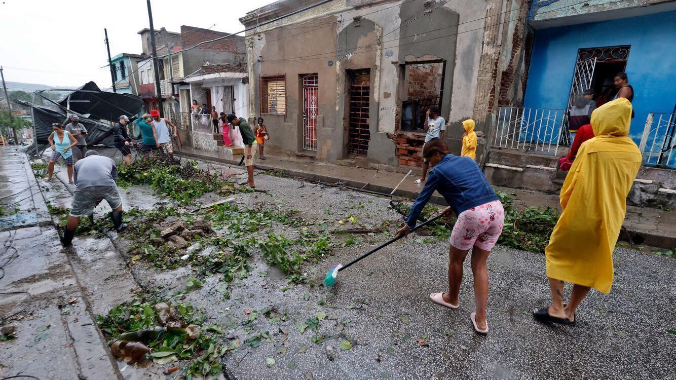 Nekoliko ljudi čisti ulice i rasklanja polomljeno granje posle uragana na Kubi