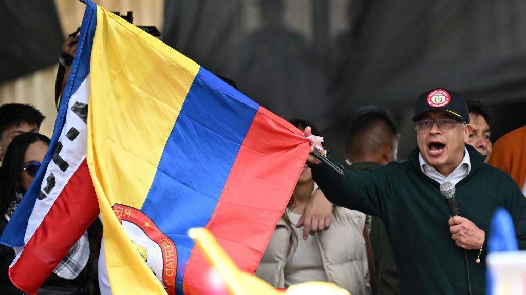 El presidente colombiano Gustavo Petro ondea una bandera nacional mientras pronuncia un discurso durante una manifestación por el Primero de Mayo (Día del Trabajo) en Bogotá el 1 de mayo de 2024.