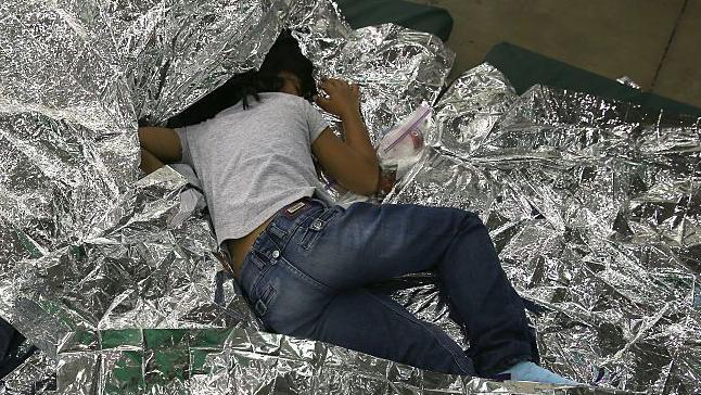 Una niña centroamericana duerme en el suelo, sobre una manta térmica plateada, en un centro de detención de la Patrulla Fronteriza de Estados Unidos en McAllen, Texas, el 8 de septiembre de 2014. (Foto: John Moore/Getty Images)