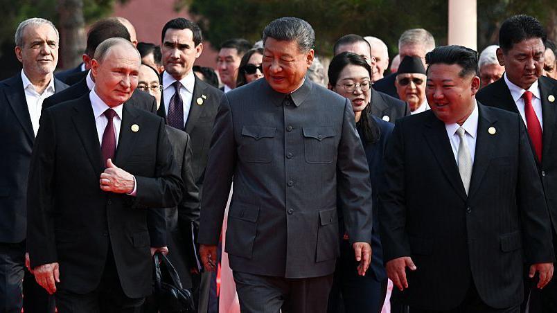 In this pool photograph distributed by the Russian state agency Sputnik, (L-R) Russia's President Vladimir Putin walks with China's President Xi Jinping and North Korea's leader Kim Jong Un before a military parade marking the 80th anniversary of victory over Japan and the end of World War II, in Beijing's Tiananmen Square on September 3, 2025