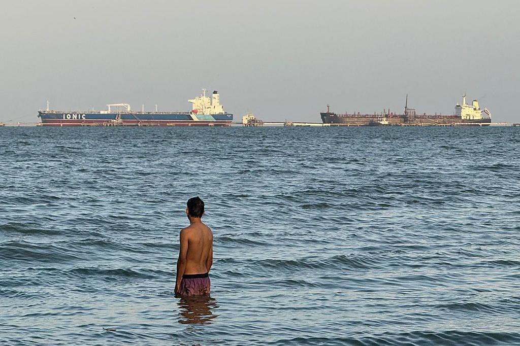 Un hombre entra en el agua con el buque petrolero Ionic Anax y el buque cisterna para petróleo y productos químicos Stef atracados al fondo, en el lago de Maracaibo, en Maracaibo, Venezuela, el 1 de marzo de 2026. Venezuela fue en el pasado un importante proveedor de crudo para EE.UU. y posee las mayores reservas probadas del mundo, con más de 303.000 millones de barriles, según el cartel petrolero mundial de la OPEP. (Foto de Margioni BERMÚDEZ / AFP vía Getty Images)