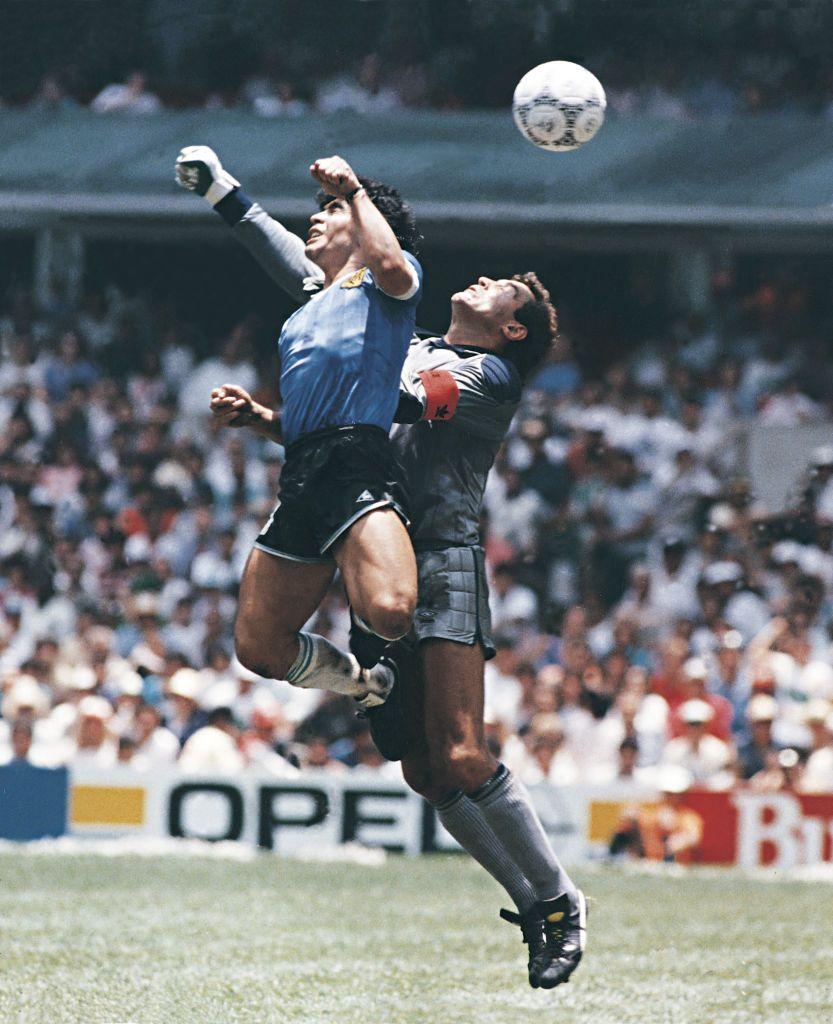 Diego Maradona, da Argentina, usa a m&atilde;o para marcar o primeiro gol de sua equipe durante uma partida das quartas de final da Copa do Mundo FIFA de 1986 entre Argentina e Inglaterra, no Est&aacute;dio Azteca, em 22 de junho de 1986. Maradona afirmou posteriormente que o gol foi marcado pela 