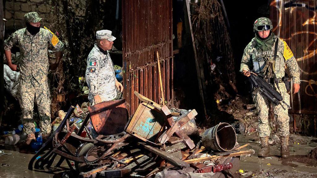 Miembros de la Guardia Nacional limpian los destrozos provocados por las inundaciones. 