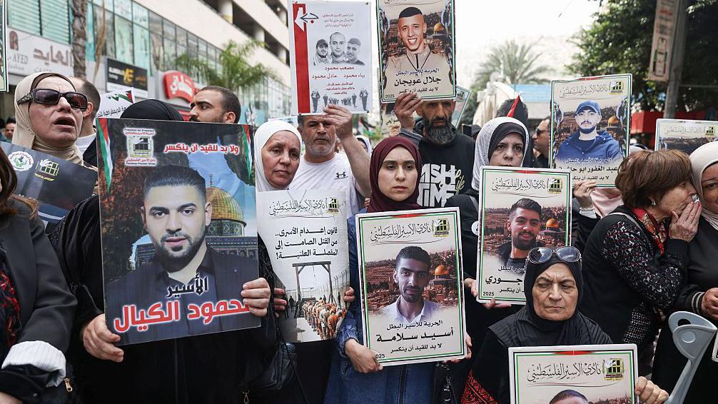 Manifestantes palestinos sostienen fotos de palestinos encarcelados durante una manifestación en Ramala, Cisjordania, para conmemorar el Día de los Presos y protestar contra la aprobación por parte del parlamento israelí de una nueva ley de pena de muerte para palestinos condenados por ataques mortales. 19 de abril de 2026.