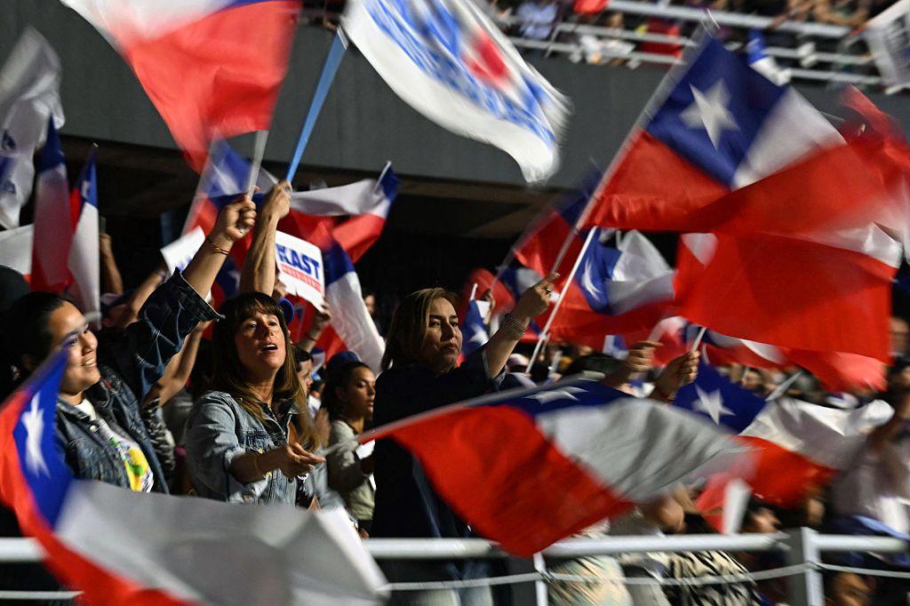 Mujeres en un acto de campaña de Kast con banderas de Chile
