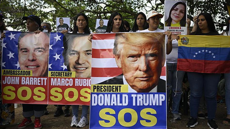 Venezolanos con pancartas de Trump.