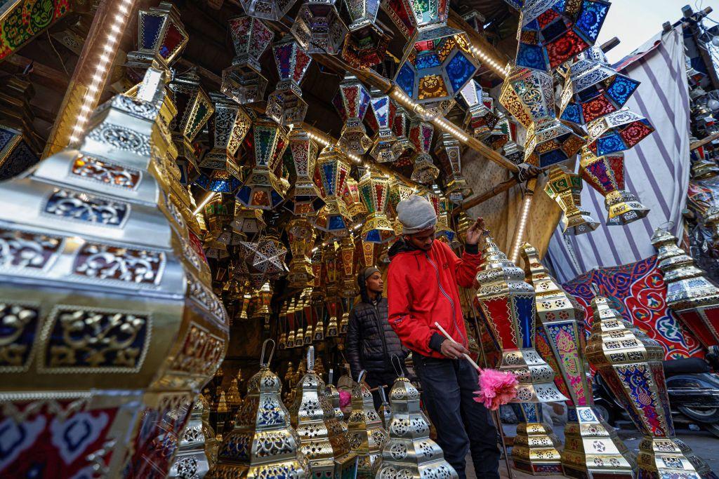 صاحب متجر يقوم بتنظيف فانوس رمضان من الغبار خارج متجر للحرف اليدوية في وسط العاصمة المصرية القاهرة