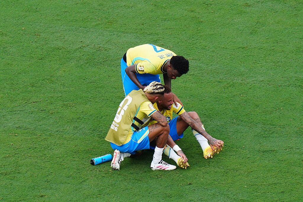 Neymar no campo sendo consolado por outros jogadores