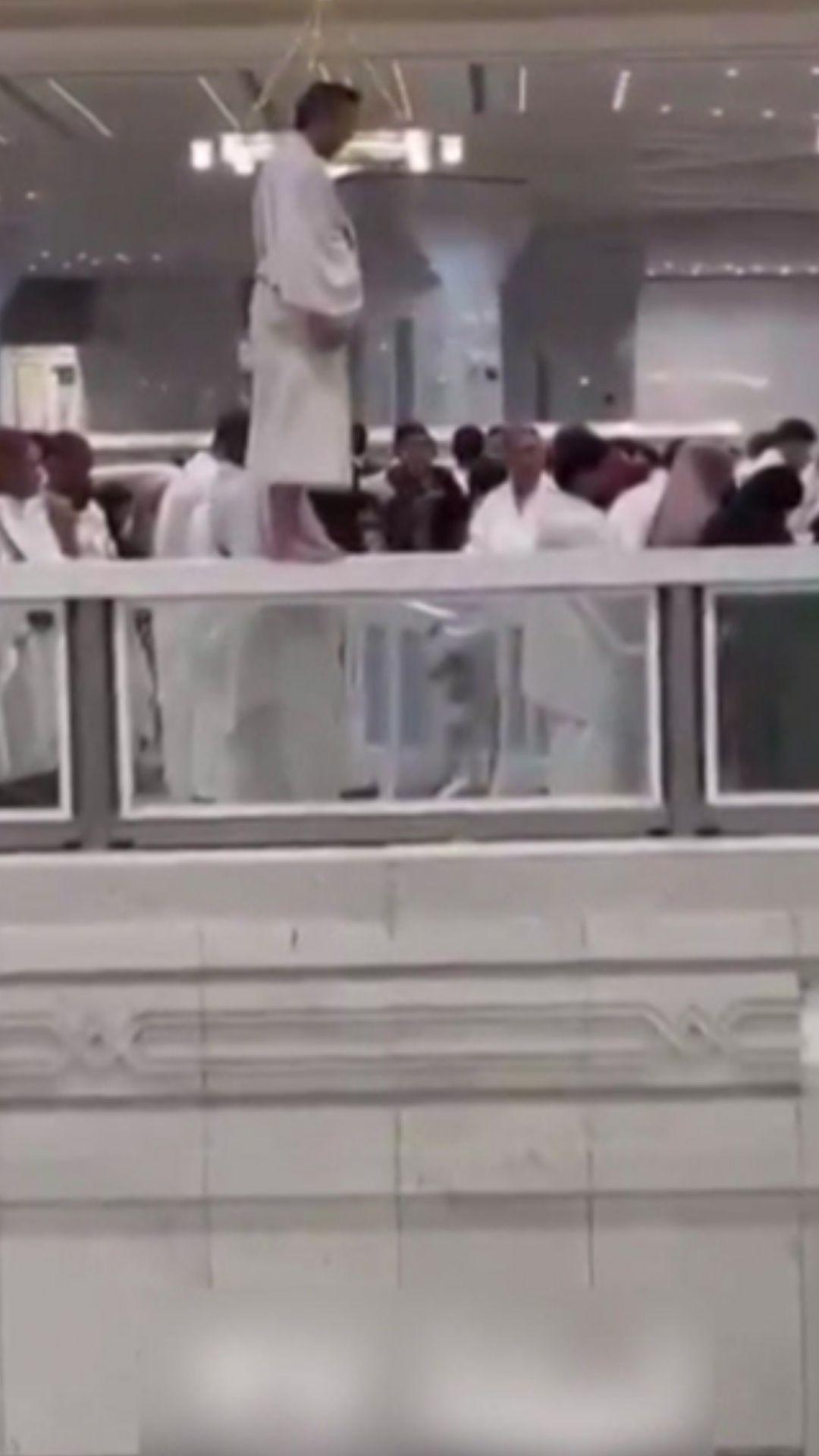 معتمر يصلي فوق حافة سور الحرم 