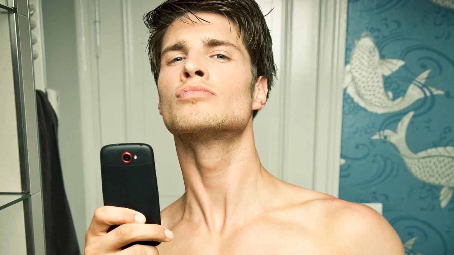 Hombre joven tomándose ua foto en el baño