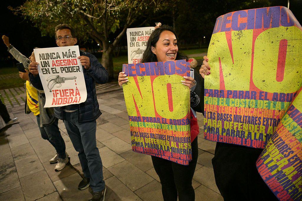 Gente manifestándose con carteles que dicen "no". 