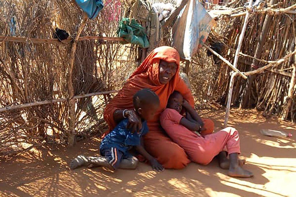 قتال عنيف في مدينة الفاشر بين الجيش السوداني وقوات الدعم السريع 2 أم سودانية نازحة مع أطفالها، تجلس على الأرض في مخيم زمزم الذي يعاني من المجاعة، شمال دارفور، في 21 يناير/كانون الثاني 2025.