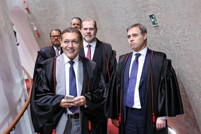 Kassio Nunes caminha no corredor para o plen&aacute;rio do TSE, seguido de Andr&eacute; Mendon&ccedil;a e Dias Toffoli, todos de terno e toga.  