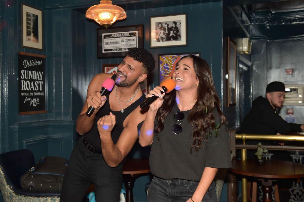 Duas pessoas cantando no karaokê