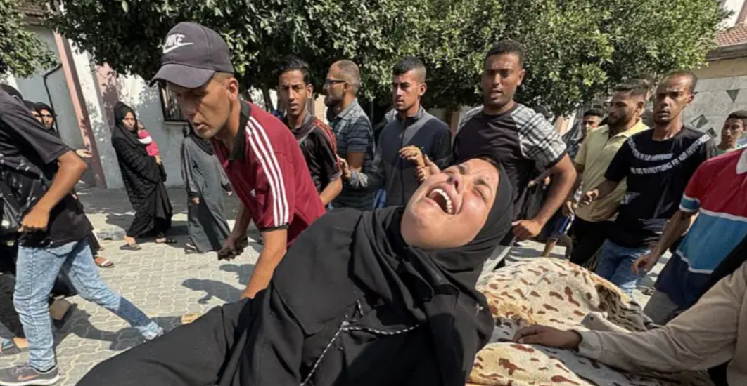Mulher chora em Gaza, com multidão ao redor