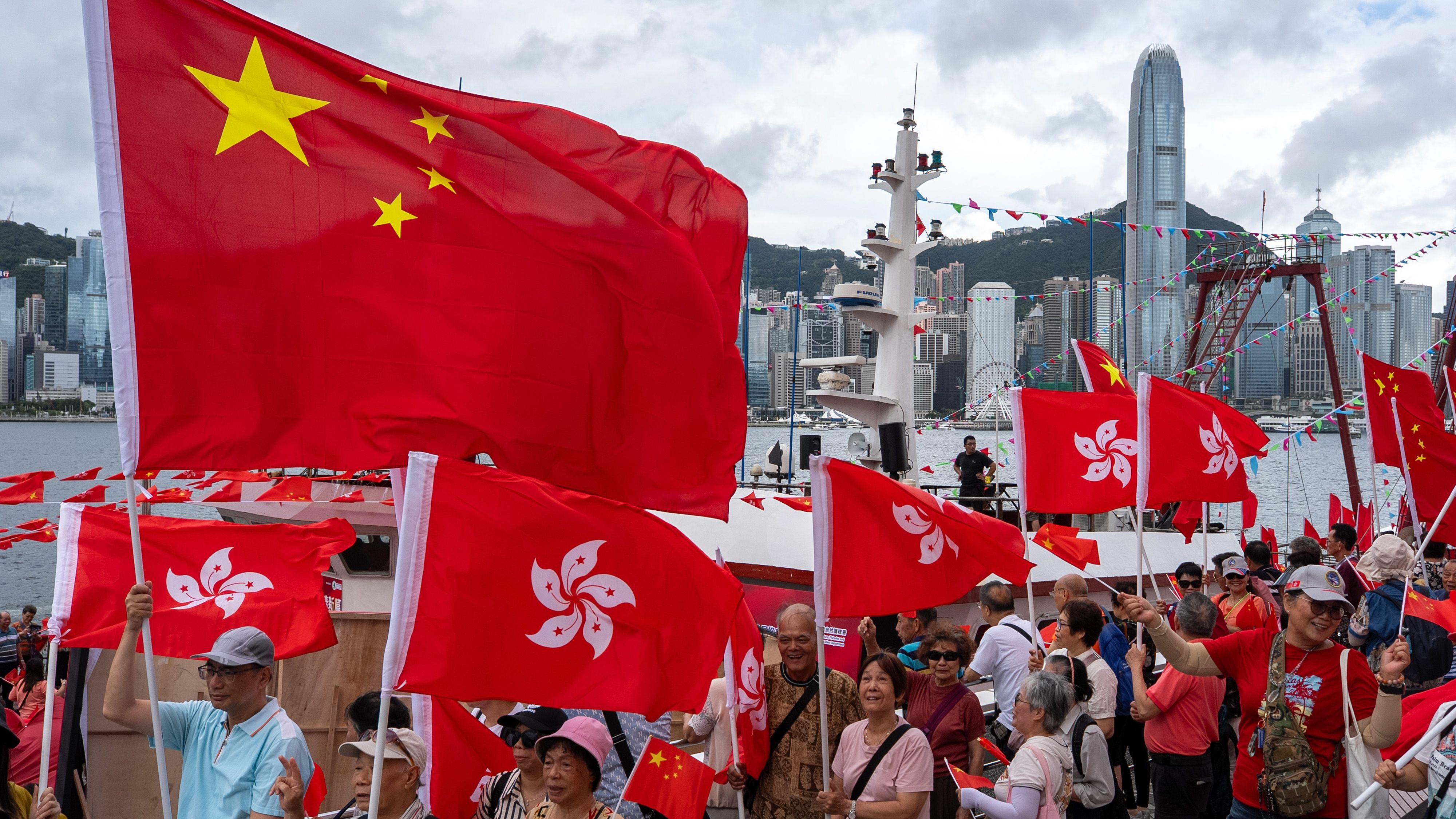 香港主權移交週年親政府社團老人成員在尖沙咀維多利亞港海旁集體揮舞中國國旗與香港區旗（1/7/2025）