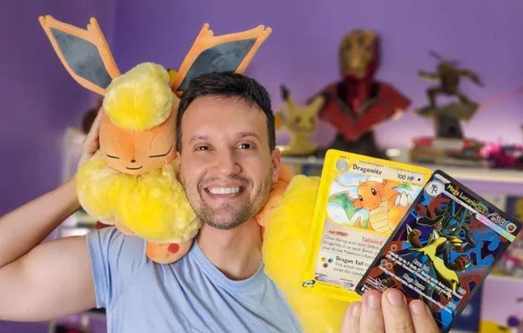 João Paulo segurando revistas e um bicho de pelúcia Pokemon