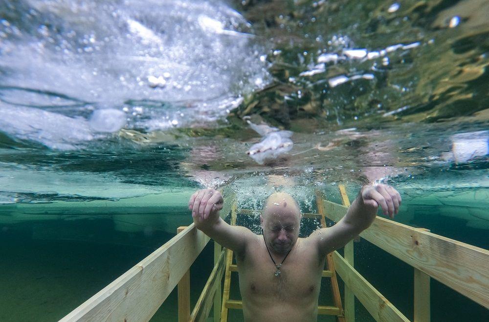 muškarac uranja u ledenu vodu tokom proslave pravoslavnog hrišćanskog praznika Bogojavljanja u gradu Stupino u Moskovskoj oblasti