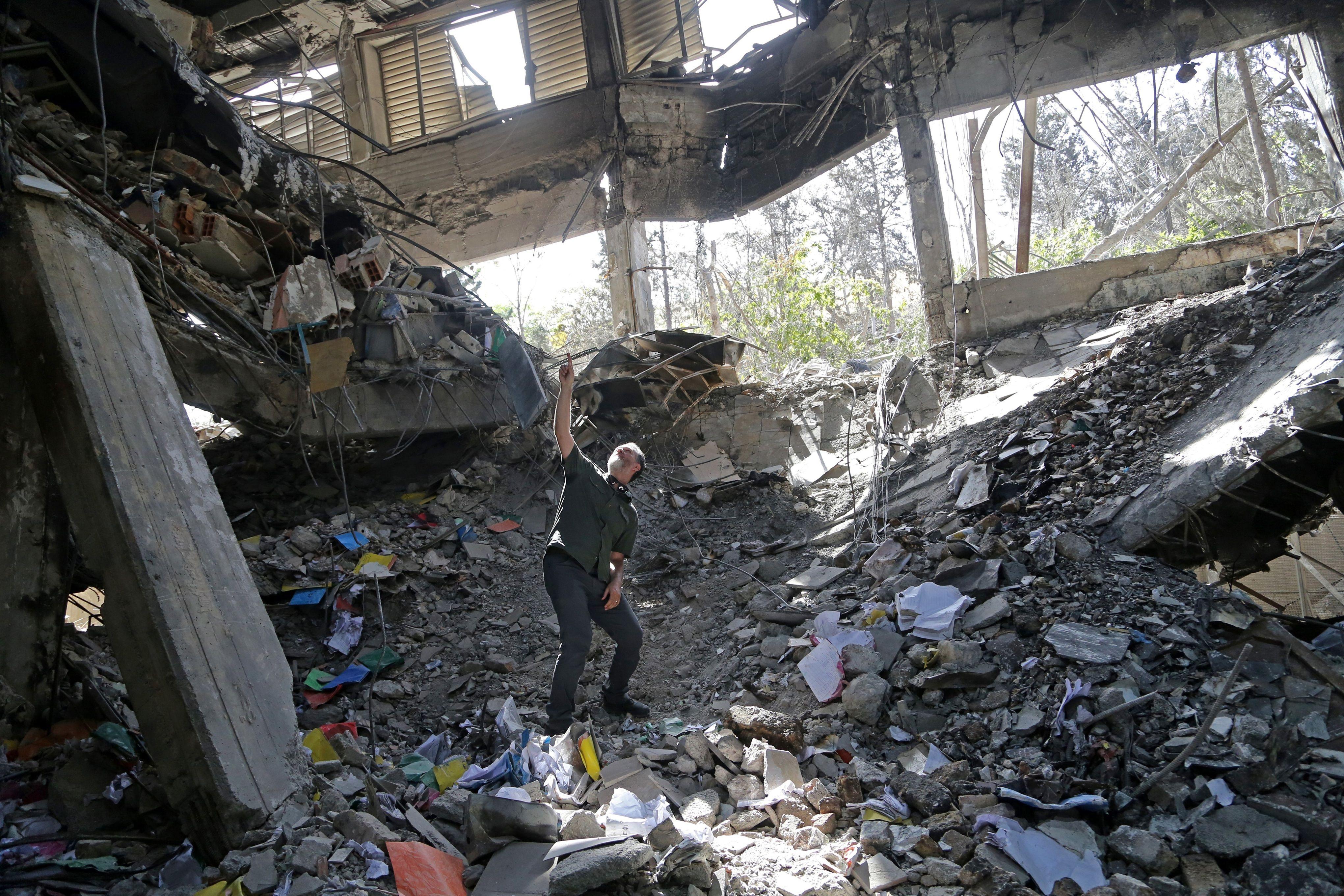 A man stands amongst the ruins of a prison building in Iran