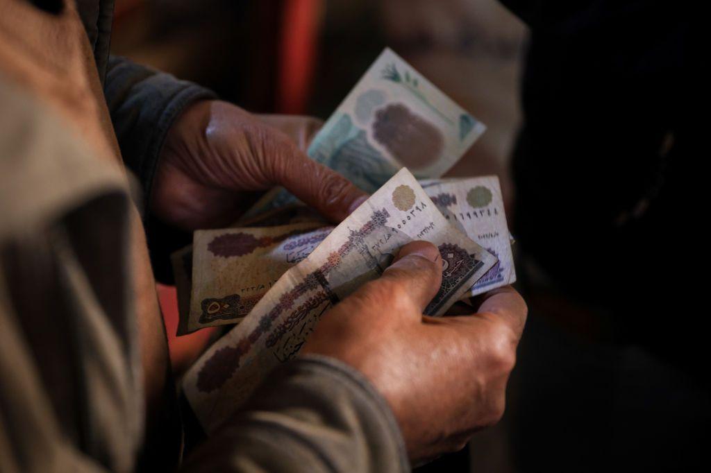 مبلغ من النقود في يد رجل، صورة بتاريخ فبراير ٢٠٢٥