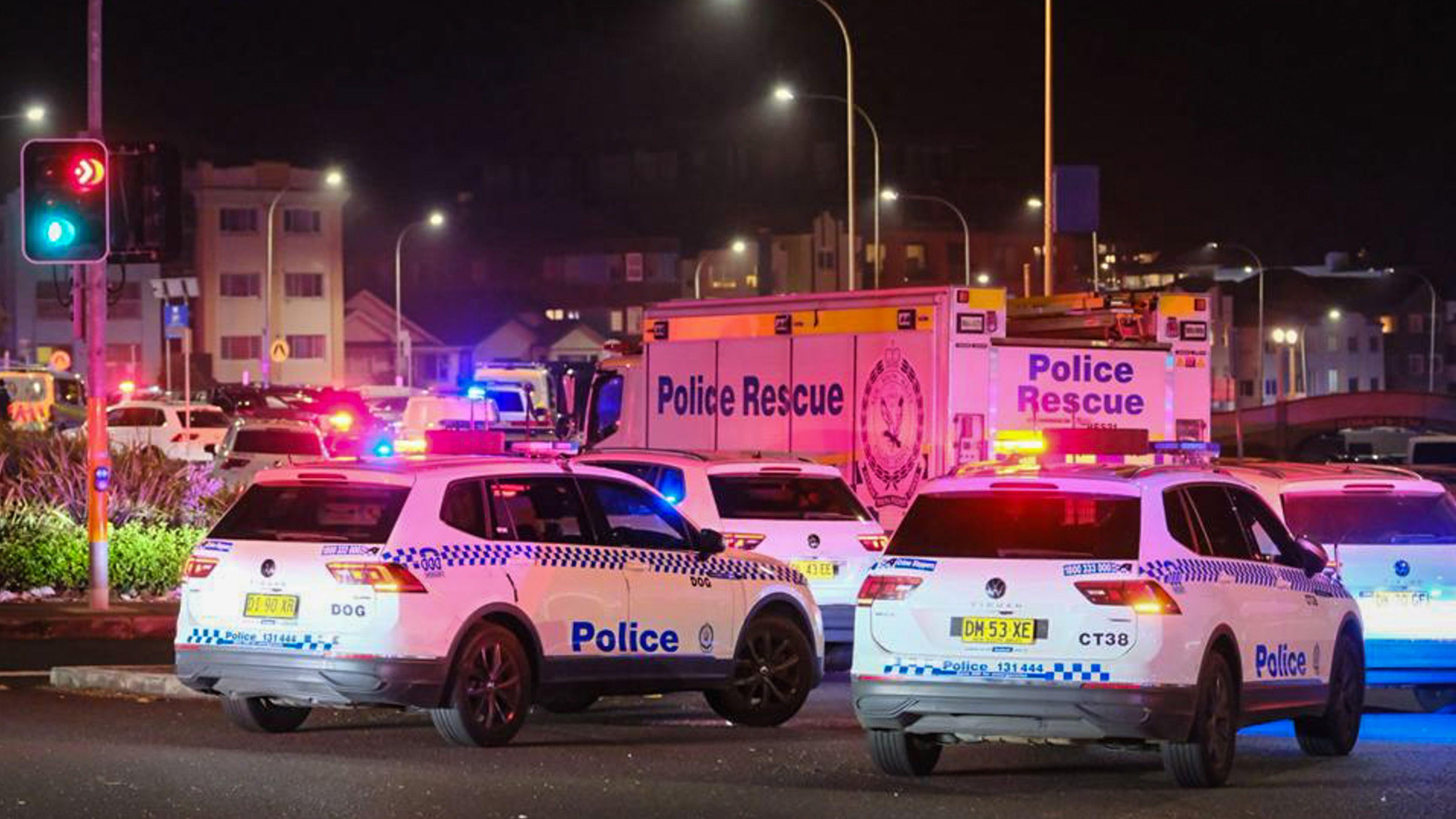 Se puede ver un mar de luces rojas y azules intermitentes, junto con vehículos policiales, en una carretera abarrotada.