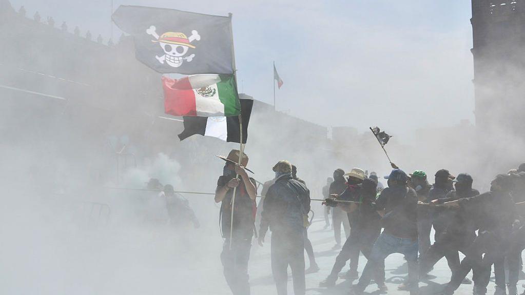 Un manifestante sostiene una bandera del manga One Piece y una bandera de México durante una protesta contra el gobierno de la presidenta Claudia Sheinbaum en la Plaza del Zócalo, en la Ciudad de México.