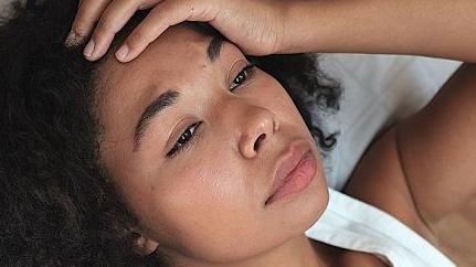 امرأة تضع يدها على جبهتها وهي تبدو قلقة