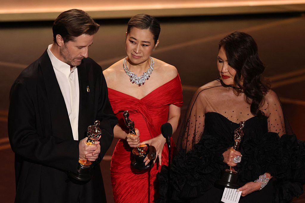 El director estadounidense Chris Appelhans (izq.), la artista de storyboards y guionista surcoreano-canadiense Maggie Kang y la productora Michelle Wong hablan en el escenario después de aceptar el Oscar a la Mejor Película de Animación por "KPop Demon Hunters" durante la 98ª ceremonia anual de los Premios de la Academia en el Dolby Theatre de Hollywood, California, el 15 de marzo de 2026. (Foto de Patrick T. Fallon / AFP a través de Getty Images)
