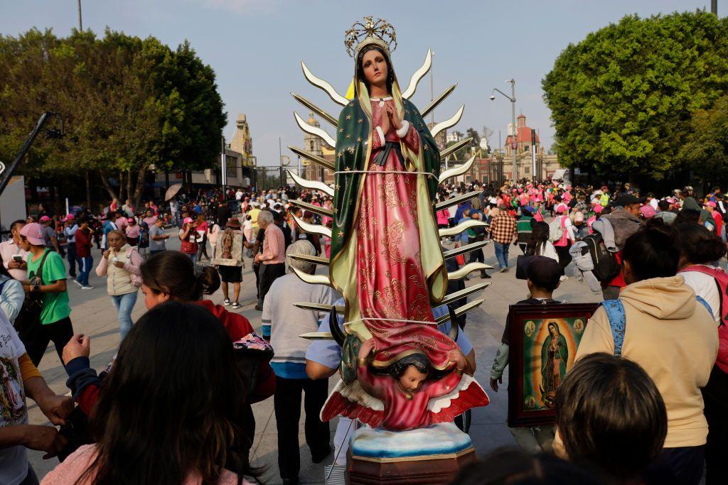 Fieles en México cargan la estatua de la Virgen de Guadalupe durante una festividad