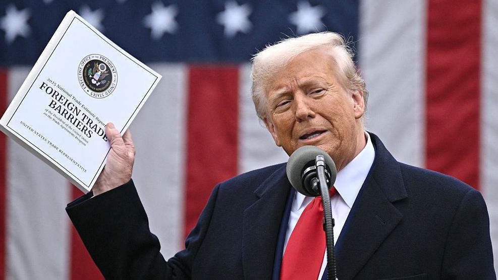 Donald Trump muestra un manual de "Barreras al comercio exterior"
