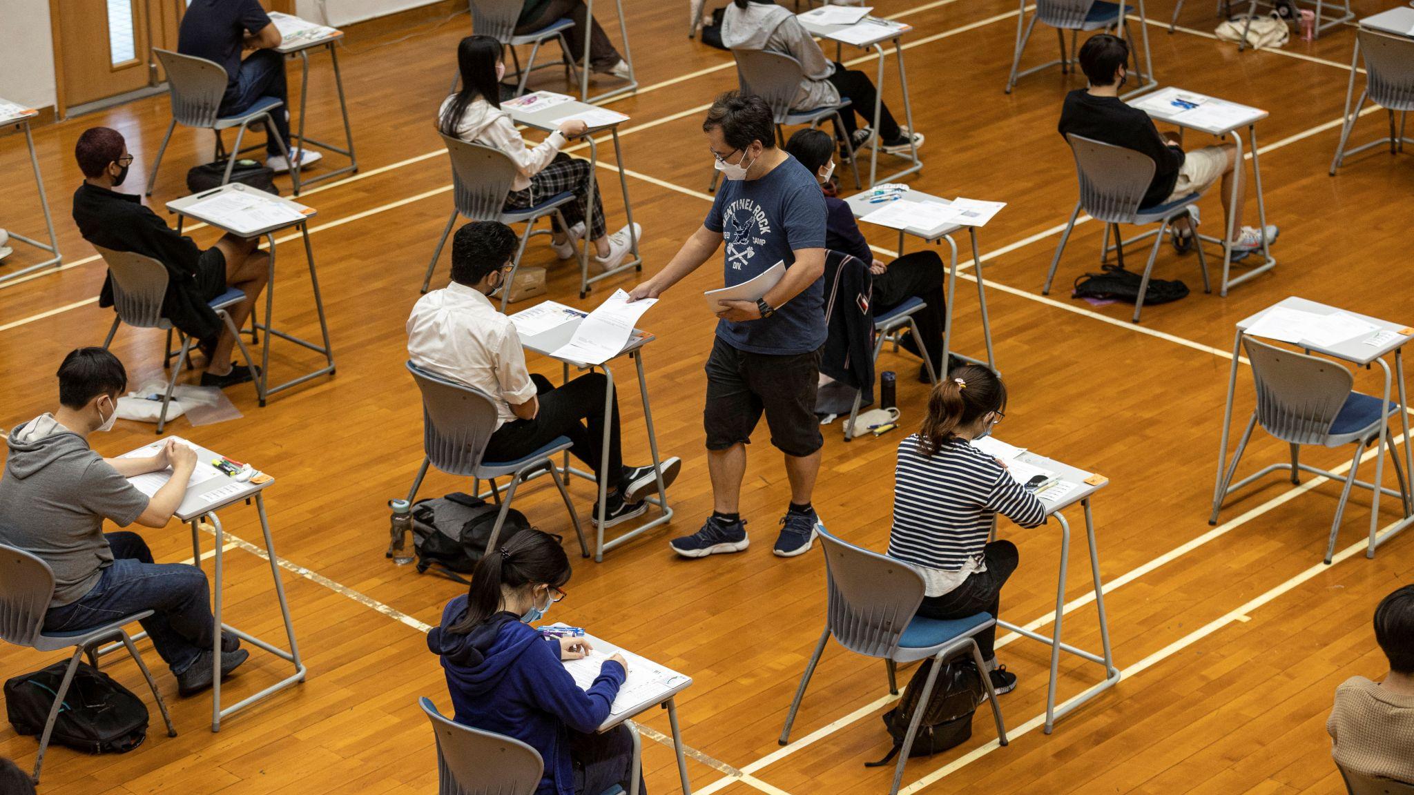 香港中學文憑考試某考場監考員向考生派發試題（資料圖片）
