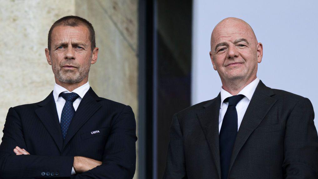 O presidente da Uefa, Aleksander Ceferin, e o presidente da Fifa, Gianni Infantino, olham das tribunas durante um jogo de futebol