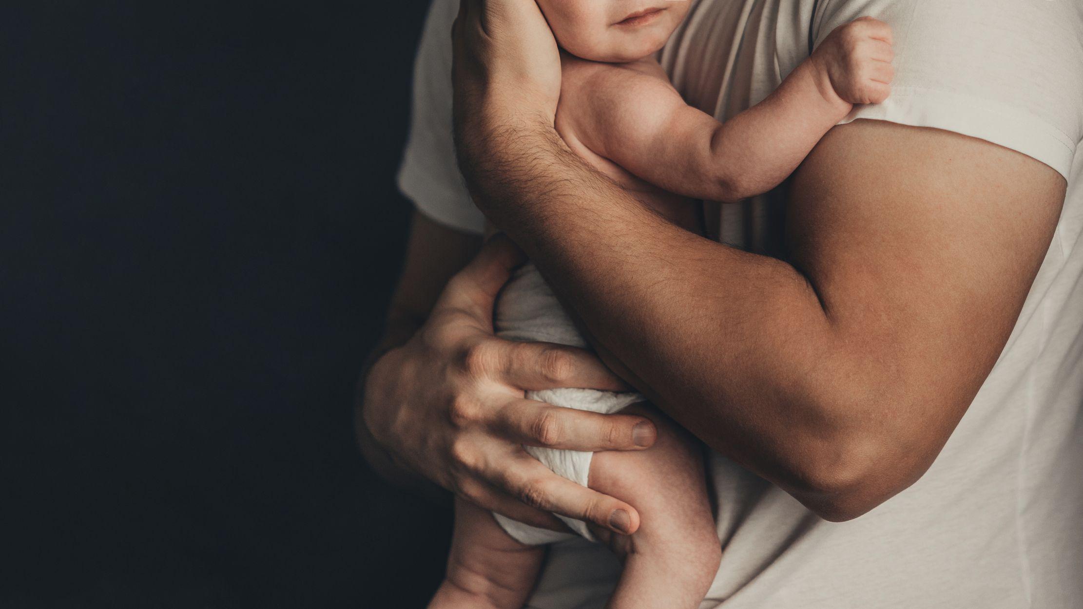 Un hombre sosteniendo a un bebé en sus brazos