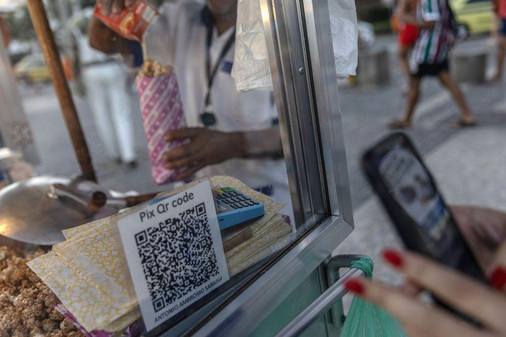 Un cliente utiliza el sistema de pago instantáneo Pix en un puesto de venta de palomitas de maíz en la playa de Ipanema, en Río de Janeiro, Brasil, el viernes 3 de mayo de 2024.