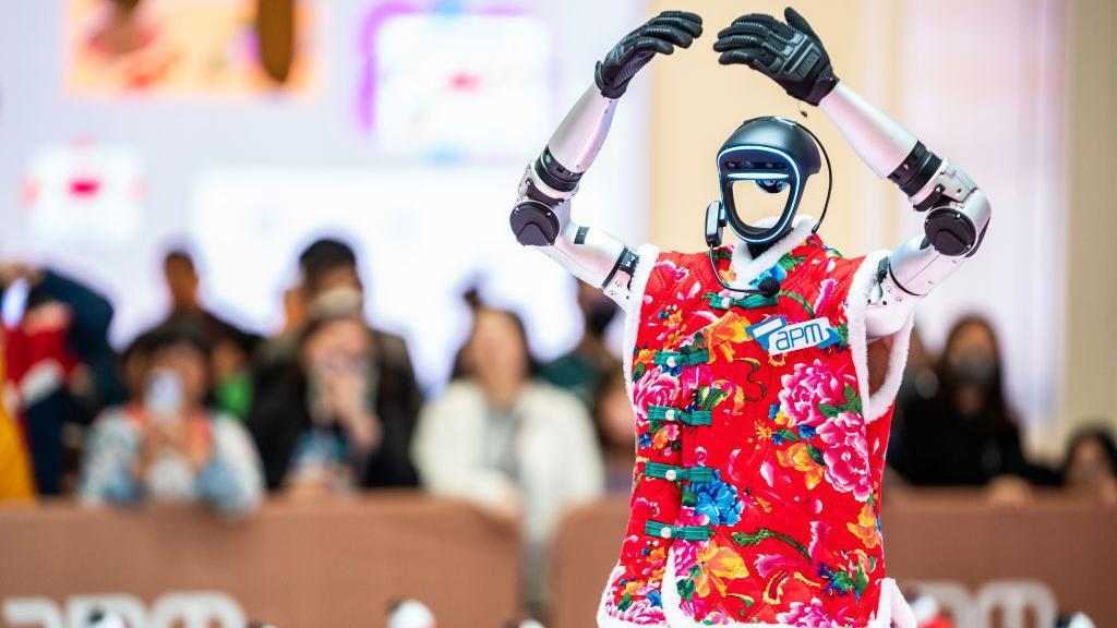 一名身穿東北花紋外套的人形機器人在觀塘APM商場舉行的人工智慧科技展上跳舞