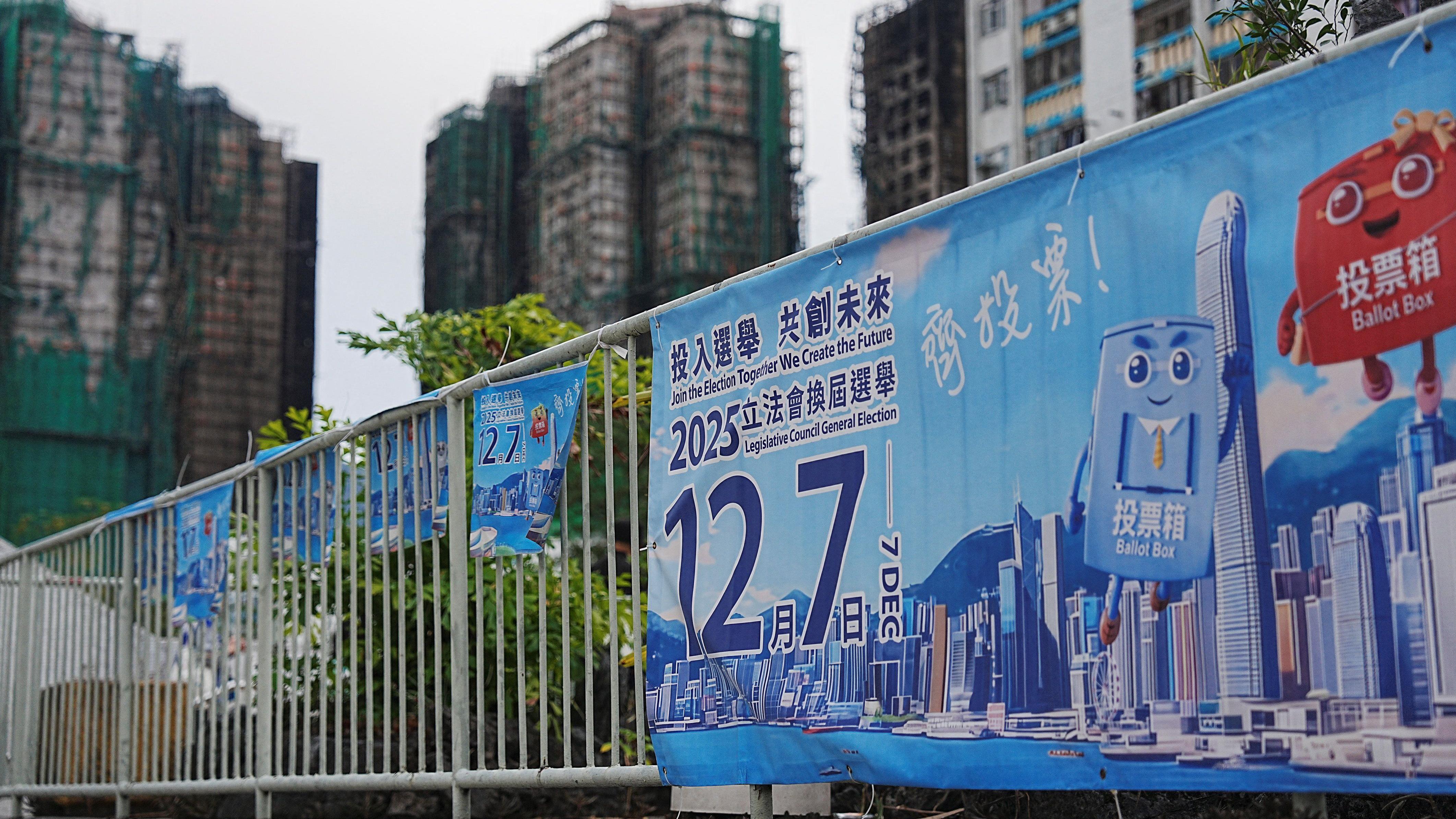 香港大埔宏福苑火場外一處路邊圍欄上懸掛著12月7日立法會選舉投票的官方宣傳橫幅（2/12/2025）
