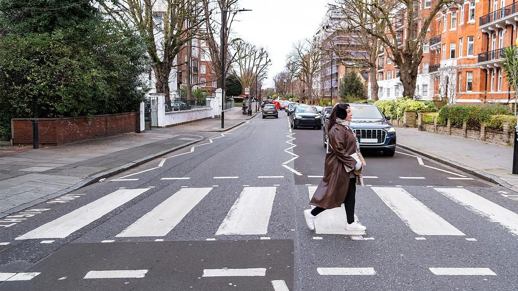 Una mujer cruzando Abbey Road, en Londres