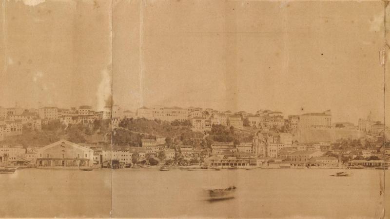 Aparentemente uma fotografia em tom s&eacute;pia mostra mar e casas de Salvador