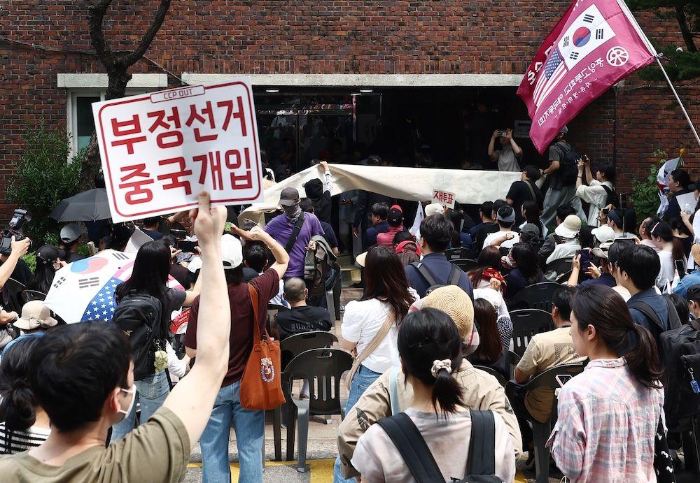 피켓과 깃발 등을 들고 시위하는 사람들