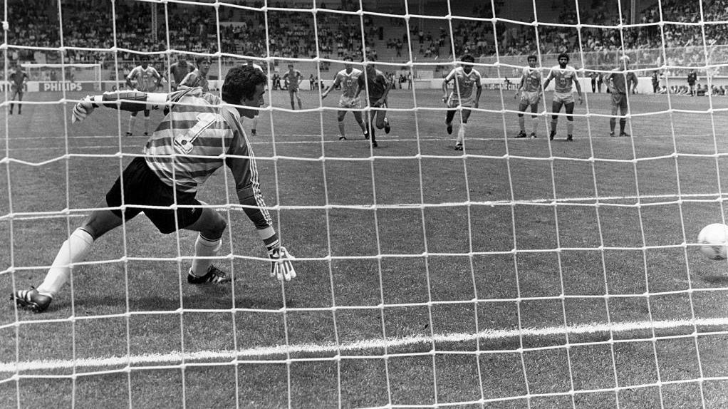 صورة بالأبيض والأسود - حارس مرمى يتلقى هدفاً - هدف بلجيكا ضد العراق في كأس العالم 1986 من ضربة جزاء