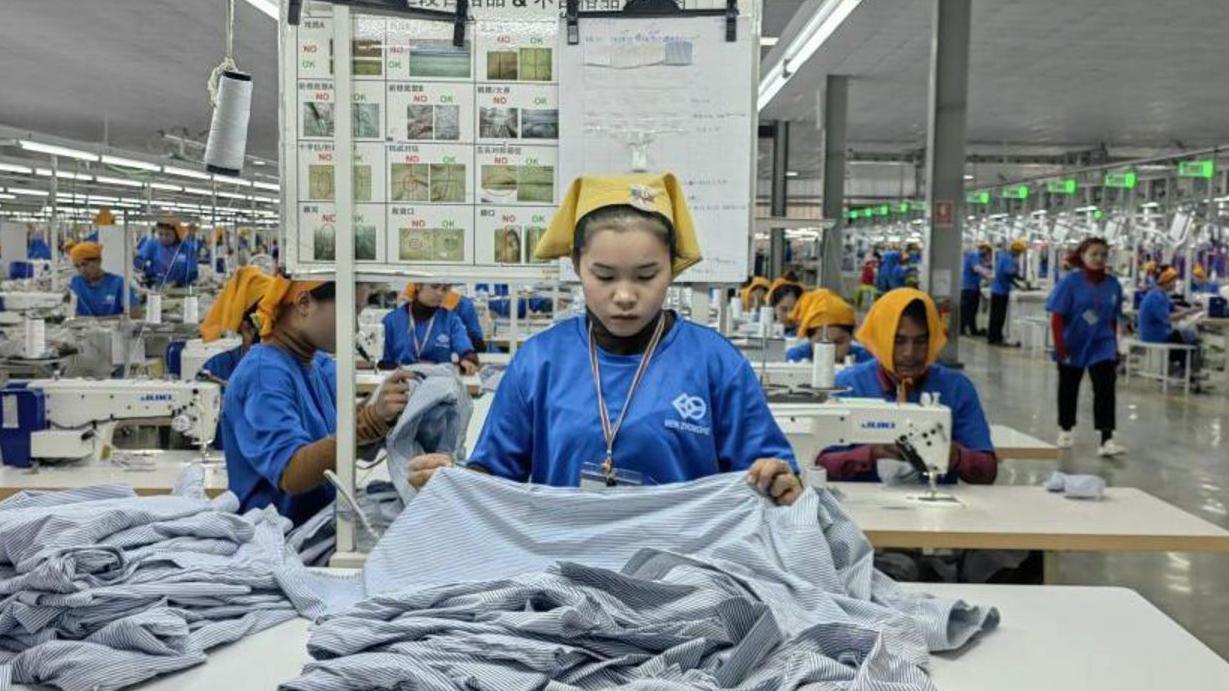 一個工人在加工衣服