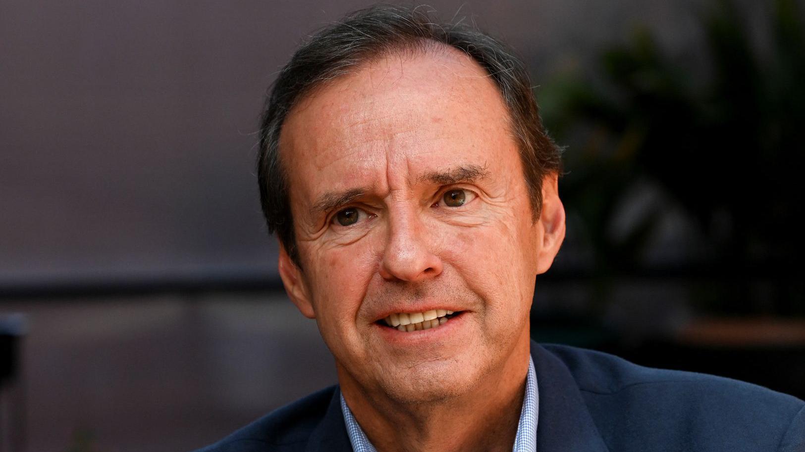 Close de Jorge Tuto Quiroga, com meio sorriso e vestindo azul.