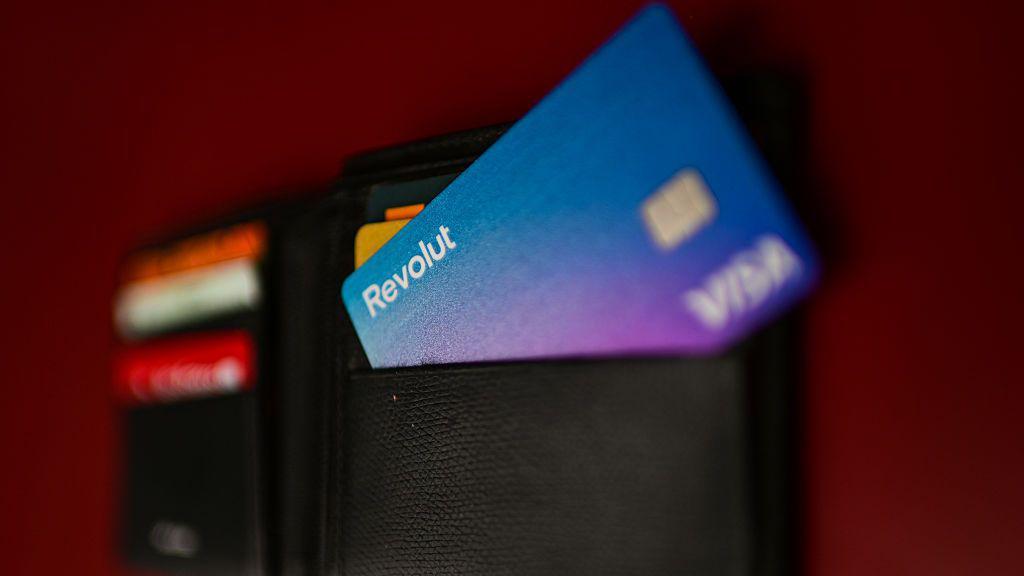 Una cartera llena de tarjetas de pago en la que destaca la morada de Revolut.