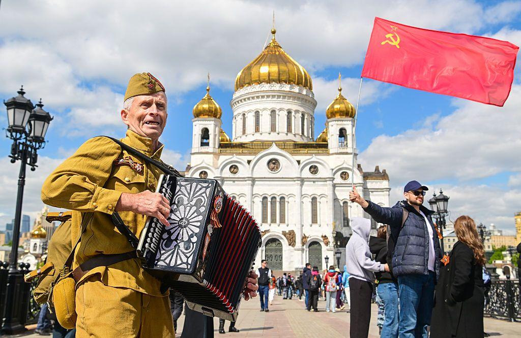 Un hombre sujeta una bandera soviética.