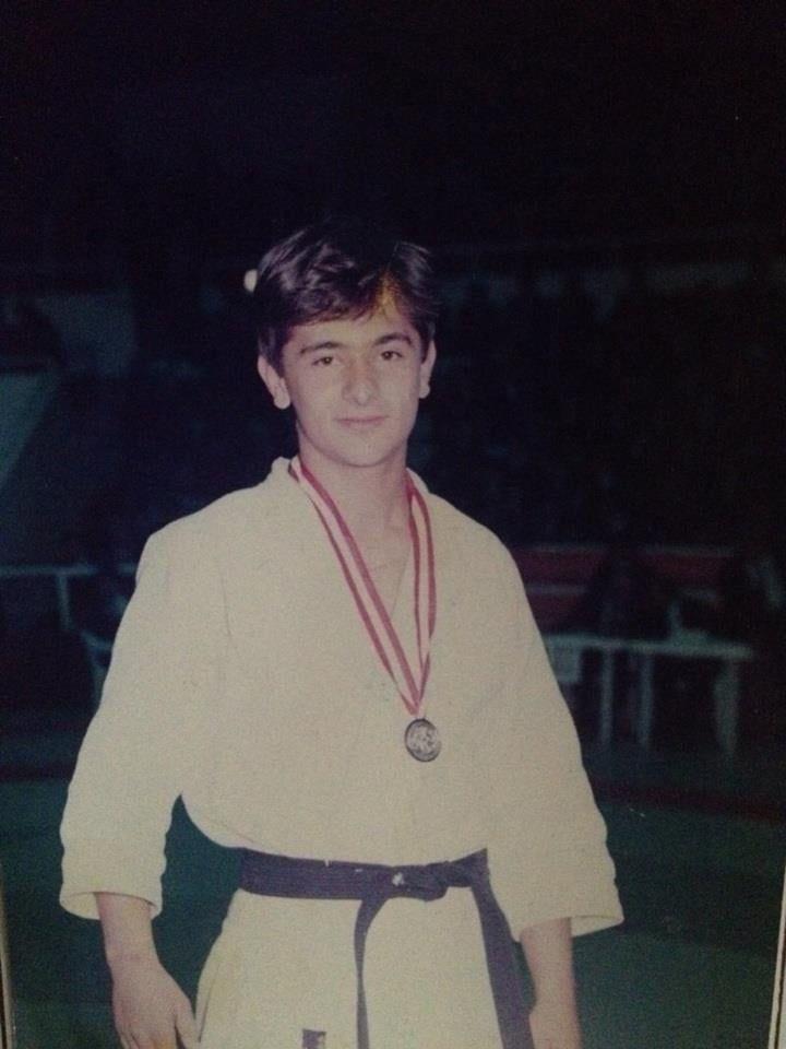 Toni com quimono e medalha, em pé e sorrindo timidamente