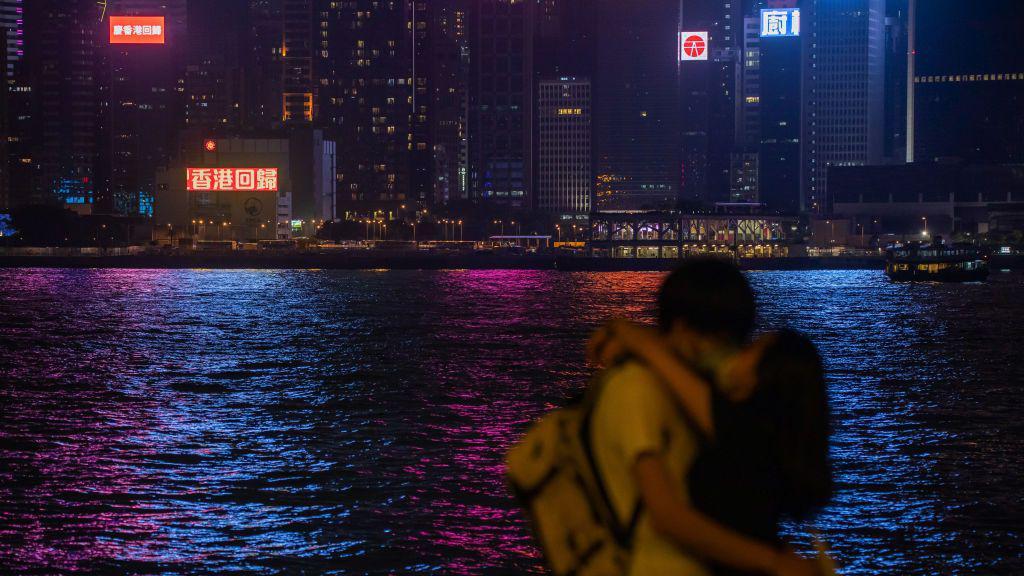 一對情侶在香港維多利亞海港前相擁接吻。